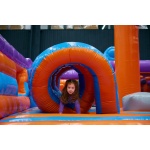 Cute girl playing on inflatable bounce house in entertainment center