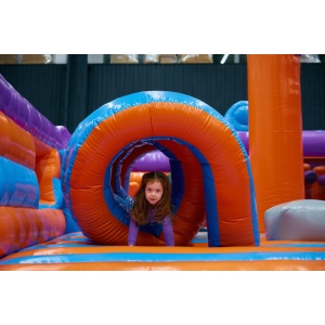 Cute girl playing on inflatable bounce house in entertainment center