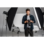 handsome professional young photographer using camera in photo studio