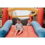 Sisters playing on inflatable slide