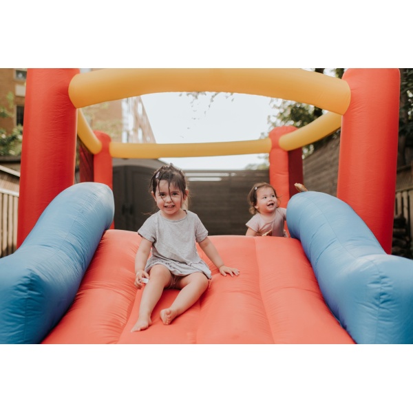 Sisters playing on inflatable slide