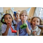 Three children holding party blowers and having fun
